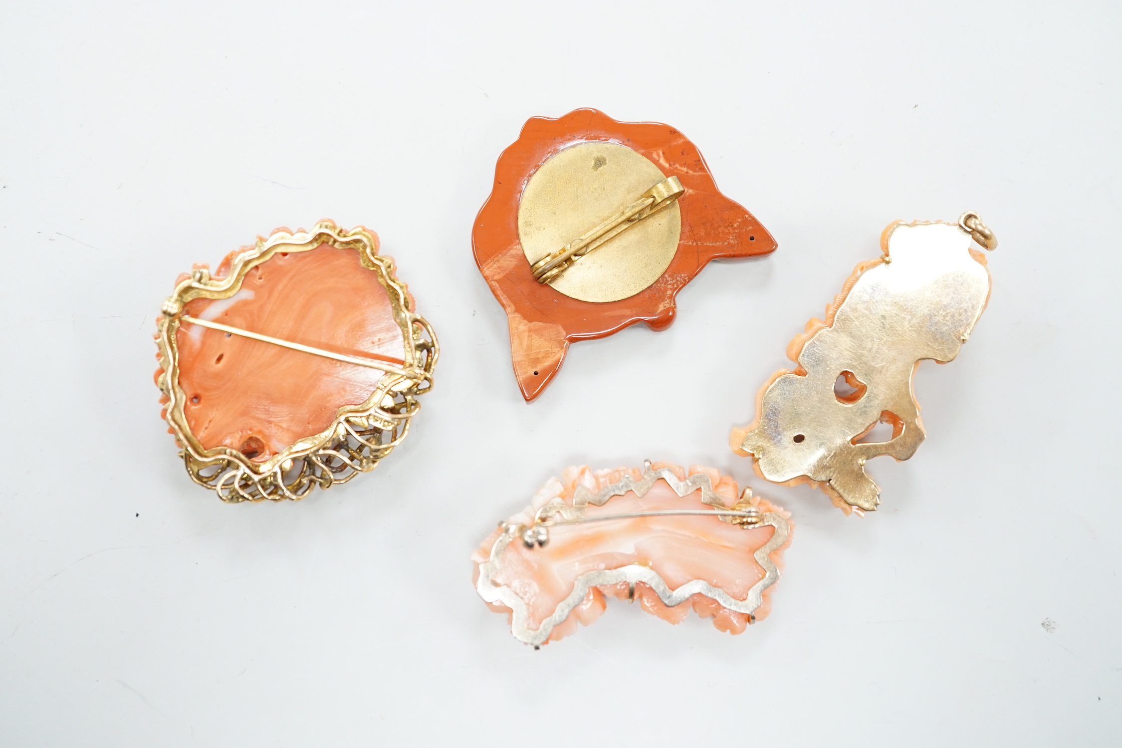 A Chinese yellow metal mounted coral pendant, carved with a grotesque beast, 52mm, a 585 mounted coral brooch, carved with roses and two other items.